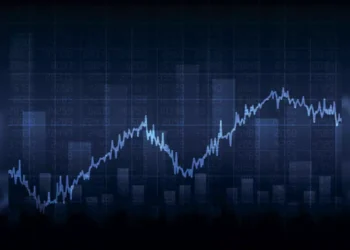 A digital image showcasing a fluctuating financial graph with a blue line representing data trends on a dark background. Various numerical values and bar charts are visible in the background, indicating financial metrics and performance analysis, highlighting the best stocks to buy in June 2024. | 5StarsStocks