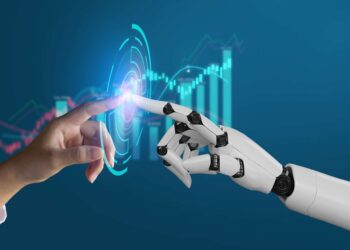 A human hand and a robotic hand reach towards each other, fingertips nearly touching. Between their fingers is a digital overlay with holographic elements, including data charts and graphs in the background, symbolizing the interaction between humans and technology, enhanced by 5StarsStocks AI for precise stock analysis. | 5StarsStocks