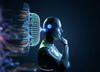A humanoid robot in profile view is deep in thought, with a network of colorful, glowing lines and nodes extending from the back of its head, symbolizing a complex neural network. The background is a dark, gradient blue, highlighting the robot and the neural patterns—much like trends in AI stocks. | 5StarsStocks