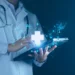 A medical professional in a white coat and stethoscope touches a glowing tablet with a holographic display of a healthcare cross and AI symbols, representing digital health technology, artificial intelligence, and the future potential of healthcare stocks. The background is dark and blurred. | 5StarsStocks