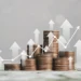 A stack of coins arranged in ascending order with white upward arrows and a line graph overlay, symbolizing financial growth and economic progress. The background is blurred with a light gray hue, reflecting robust financial health. | 5StarsStocks