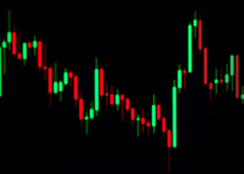 A digital display showcases a candlestick chart with red and green bars on a black background, effectively illustrating fluctuating trading chart patterns. | 5StarsStocks