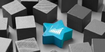 A blue star-shaped block with a white graph icon, symbolizing the best dividend stocks, stands out among a group of gray cube-shaped blocks. | 5StarsStocks