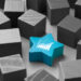 A blue star-shaped block with a white graph icon, symbolizing the best dividend stocks, stands out among a group of gray cube-shaped blocks. | 5StarsStocks
