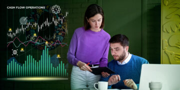 A woman and a man are analyzing data on a tablet in an office. A laptop and coffee cups rest on the desk. The digital graph titled "Cash Flow Operations" displays fluctuating lines, hinting at their focus on financial analysis and potential applications for swing trading strategies. | 5StarsStocks
