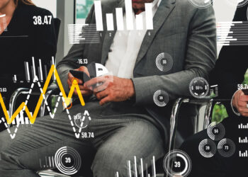 Three people in business attire sit side by side looking at their phones, overlaid with various data visualizations such as graphs, charts, and numerical statistics. | 5StarsStocks