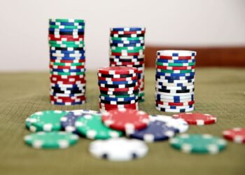 Stacks of colorful poker chips on a green table ready for a game.